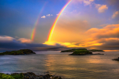 Double rainbow over the ocean during a sunset boat tour in Newfoundland.
